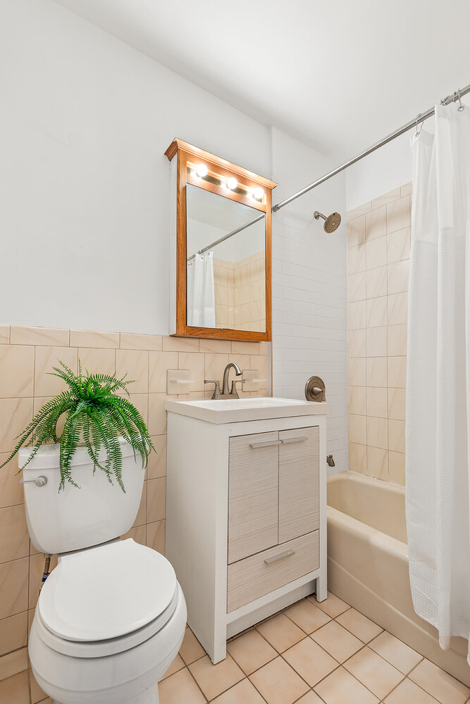 9425 Shore Road, Unit 6C Brooklyn, NY 11209 - Photo 5 of 9 a bathroom with a sink mirror vanity and toilet