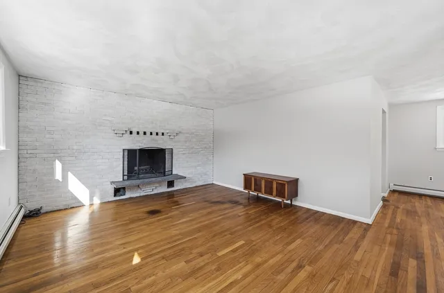 a room with a wooden floor and a fireplace