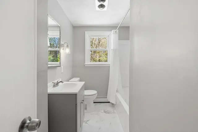 a bathroom with a sink mirror and toilet