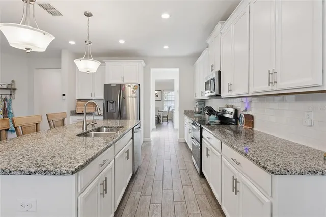 a kitchen with granite countertop white cabinets and white appliances