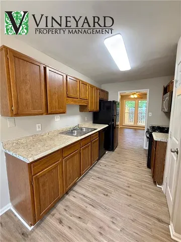 a kitchen with granite countertop a sink cabinets and wooden floor