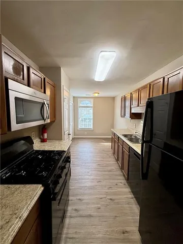 a kitchen with granite countertop a stove top oven and cabinets