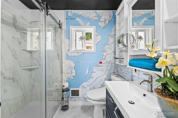 a bathroom with a sink vanity mirror and toilet