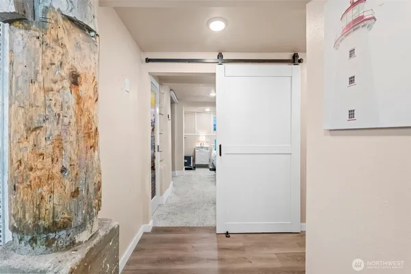 a view of a hallway with wooden floor and closet