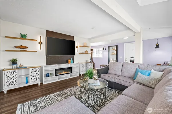 a living room with furniture a flat screen tv and a fireplace