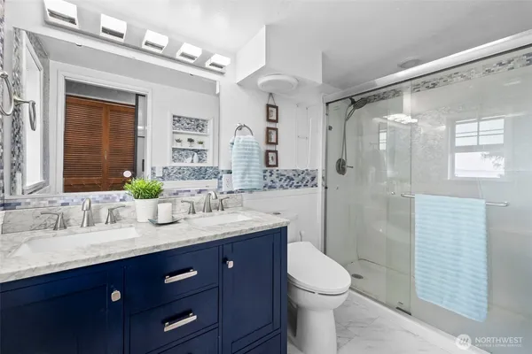 a bathroom with a granite countertop sink toilet and mirror