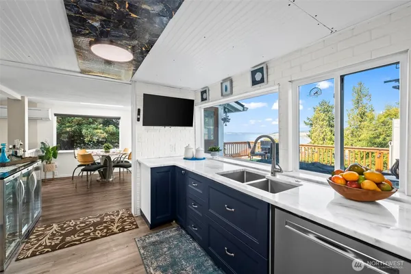 a kitchen with stainless steel appliances granite countertop a sink dishwasher stove and cabinets with wooden floor