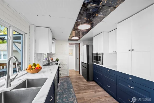 a kitchen with granite countertop a sink stainless steel appliances and cabinets