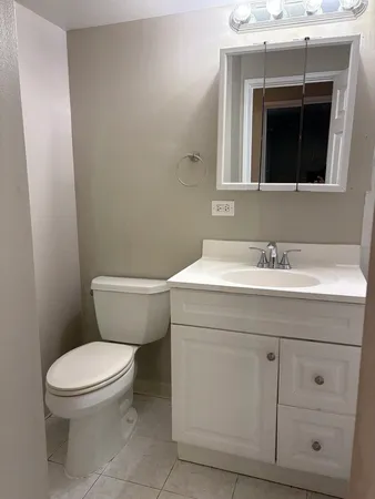 a bathroom with a toilet sink and mirror