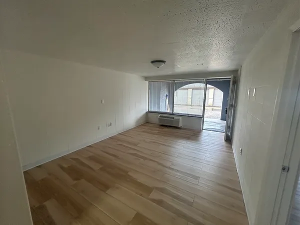 a view of a room with wooden floor