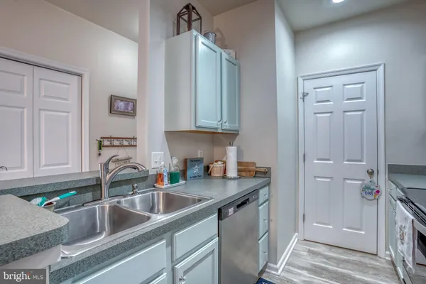 a kitchen with sink a refrigerator and cabinets