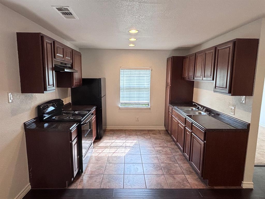 5003 Bryan Street, Unit 8 Dallas, TX 75206 - Photo 3 of 13 a kitchen with granite countertop a stove top oven microwave and cabinets