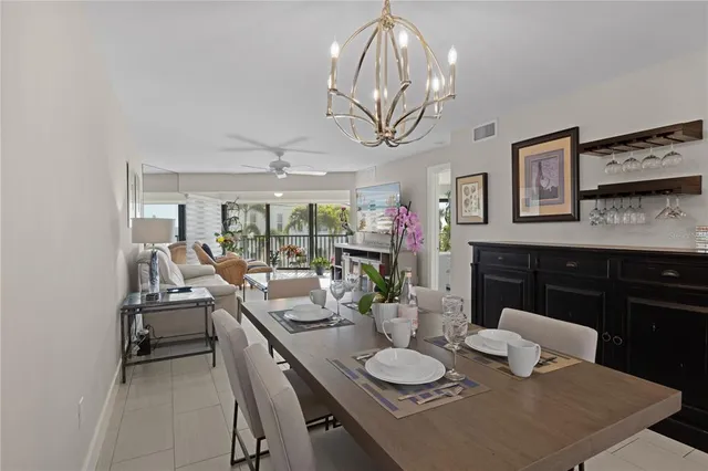 a view of a dining room with furniture a chandelier and wooden floor