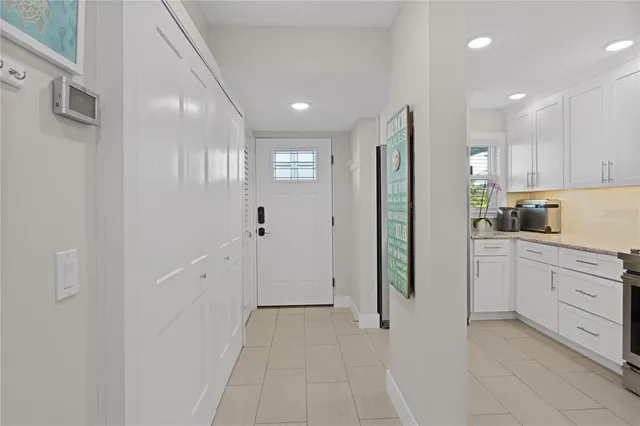a kitchen with white cabinets and refrigerator