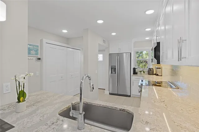 a very nice looking kitchen with a large mirror and stainless steel appliances