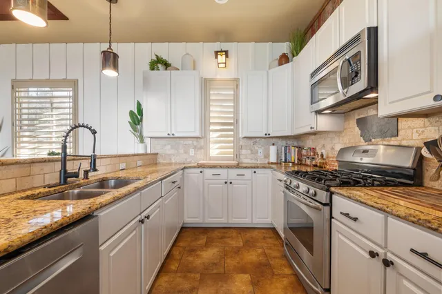 a kitchen with stainless steel appliances granite countertop a sink and stove