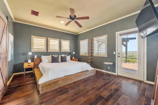 a large bedroom with a bed and wooden floor