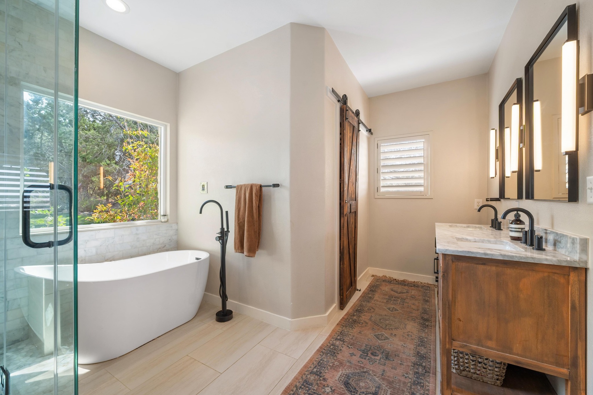 13602 Couri Pass Austin, TX 78738 - Photo 21 of 36 a bathroom with a tub a sink a mirror and a window