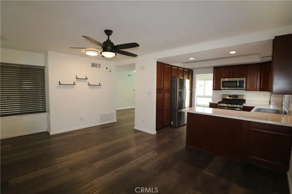 a kitchen with granite countertop a refrigerator and a stove top oven