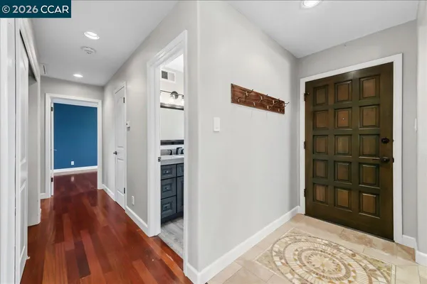 a view of hallway with wooden floor and closet
