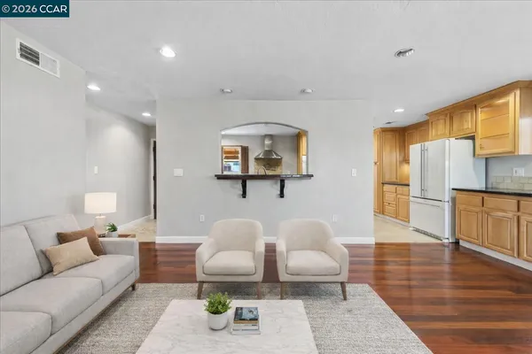 a living room with furniture and a wooden floor