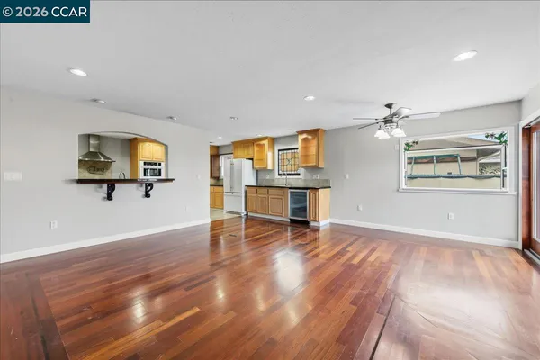 a view of a livingroom with wooden floor and a ceiling fan