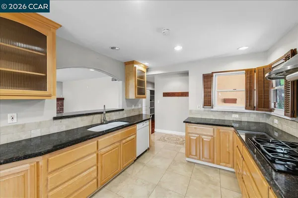 a large kitchen with stainless steel appliances granite countertop a stove and a sink