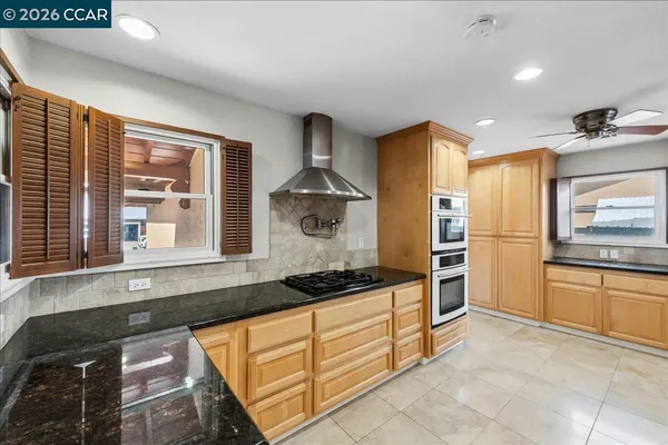 a kitchen with stainless steel appliances granite countertop a stove and a refrigerator