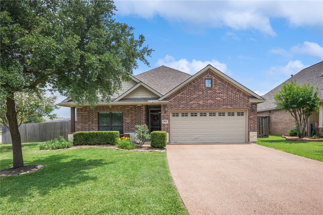 View of front facade with brick siding, a garage,