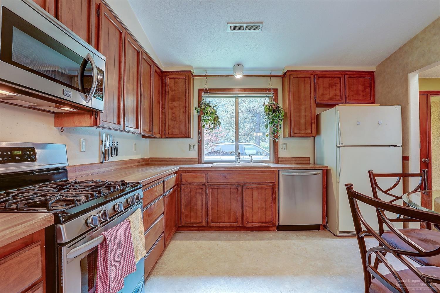 20358 Donkey Sled Road Bend, OR 97702 - Photo 5 of 17 a kitchen with stainless steel appliances granite countertop a stove a sink dishwasher and a refrigerator