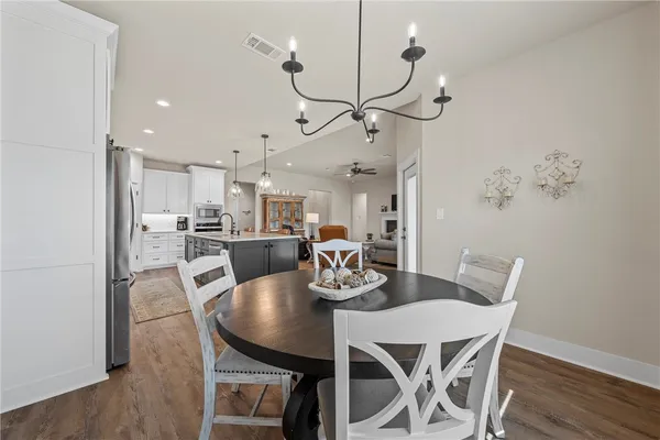 a dining room with furniture a chandelier and wooden floor