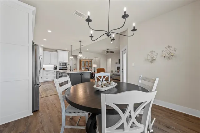 a dining room with furniture a chandelier and wooden floor