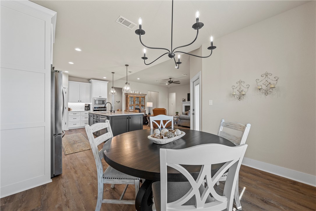 848 Gallant Fox Hewitt, TX 76643 - Photo 12 of 32 a dining room with furniture a chandelier and wooden floor