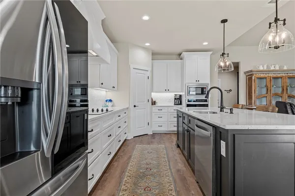 a kitchen with stainless steel appliances granite countertop a sink and a refrigerator