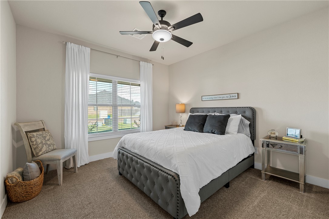 848 Gallant Fox Hewitt, TX 76643 - Photo 22 of 32 a bedroom with a bed and a chandelier