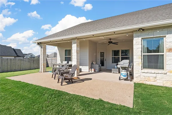a view of a patio with table and chairs with wooden fence