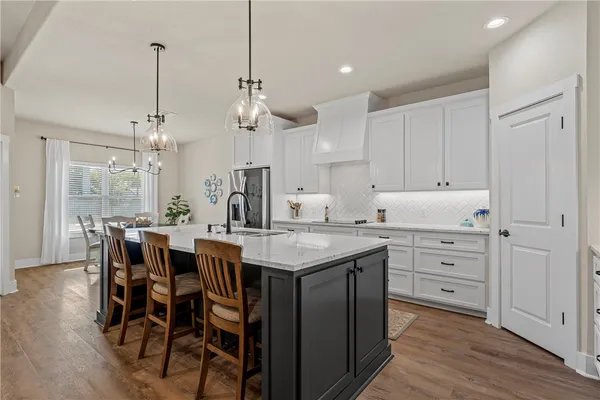 a kitchen with center island white cabinets and stainless steel appliances