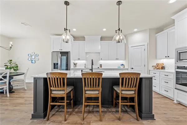 a dining room with furniture a chandelier and wooden floor