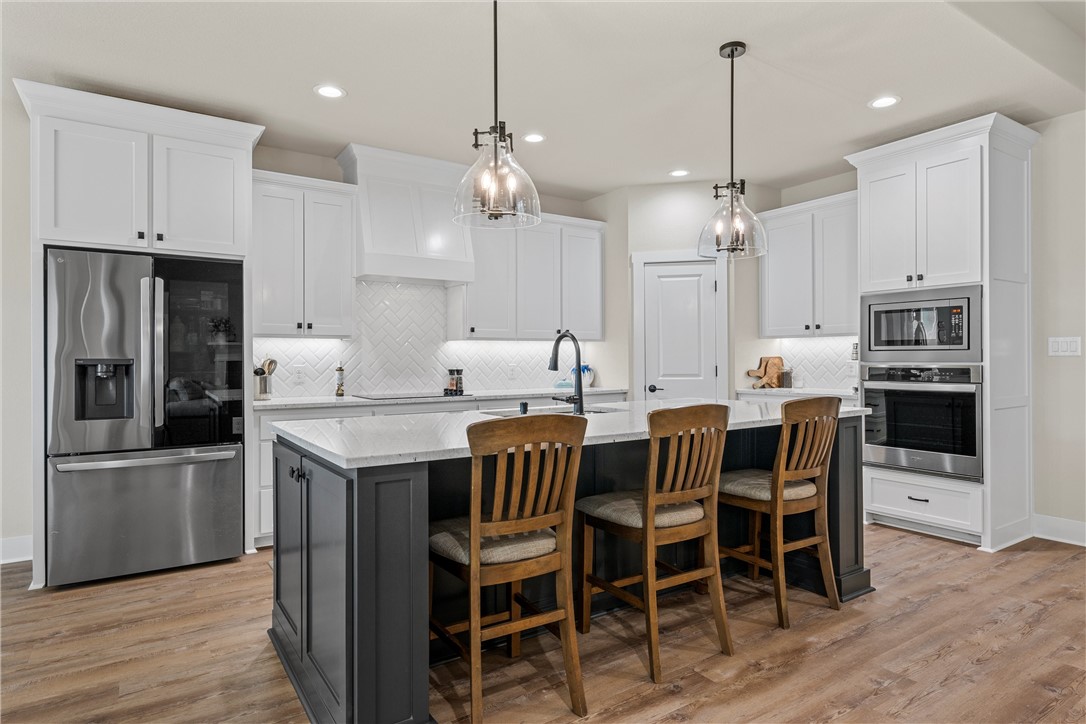 848 Gallant Fox Hewitt, TX 76643 - Photo 10 of 32 a kitchen with stainless steel appliances kitchen island granite countertop a dining table chairs and white cabinets