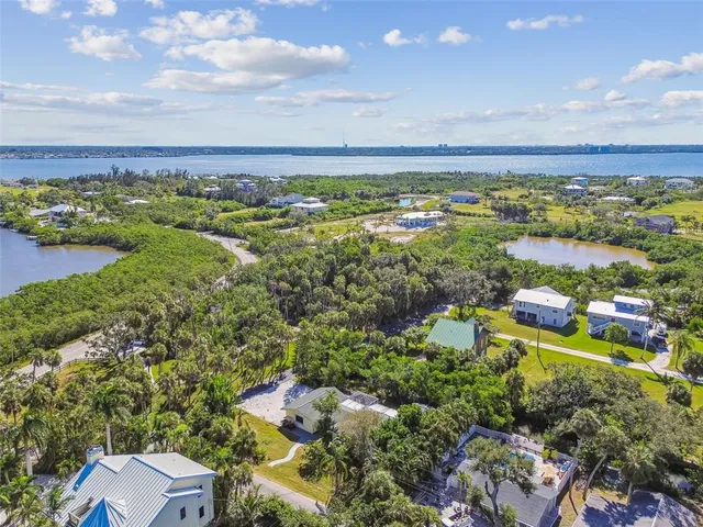 an aerial view of ocean with residential houses with outdoor space and swimming pool