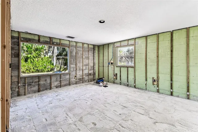 a view of an empty room with floor to ceiling window and stairs