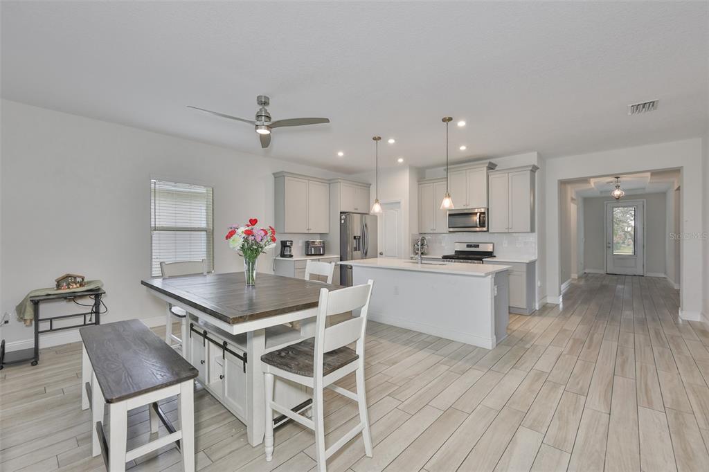 5418 Silver Sun Drive Apollo Beach, FL 33572 - Photo 11 of 65 a kitchen with stainless steel appliances kitchen island hardwood floor sink stove and white cabinets