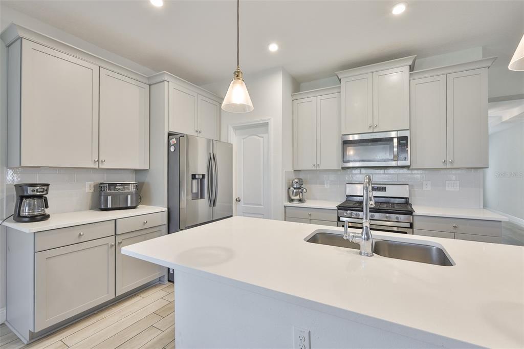 5418 Silver Sun Drive Apollo Beach, FL 33572 - Photo 16 of 65 a kitchen with kitchen island white cabinets and refrigerator