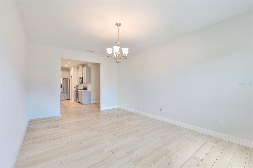 5418 Silver Sun Drive Apollo Beach, FL 33572 - Photo 26 of 65 a view of a hallway with wooden floor and a chandelier