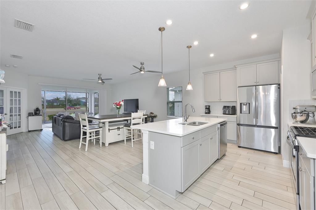 5418 Silver Sun Drive Apollo Beach, FL 33572 - Photo 10 of 65 a large kitchen with kitchen island a large island a sink stainless steel appliances and cabinets