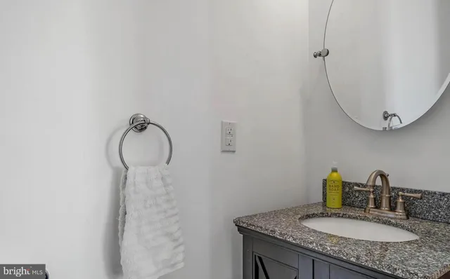 a bathroom with a granite countertop sink toilet a mirror and shower