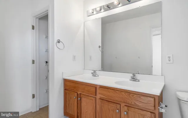 a bathroom with a granite countertop sink a toilet and shower