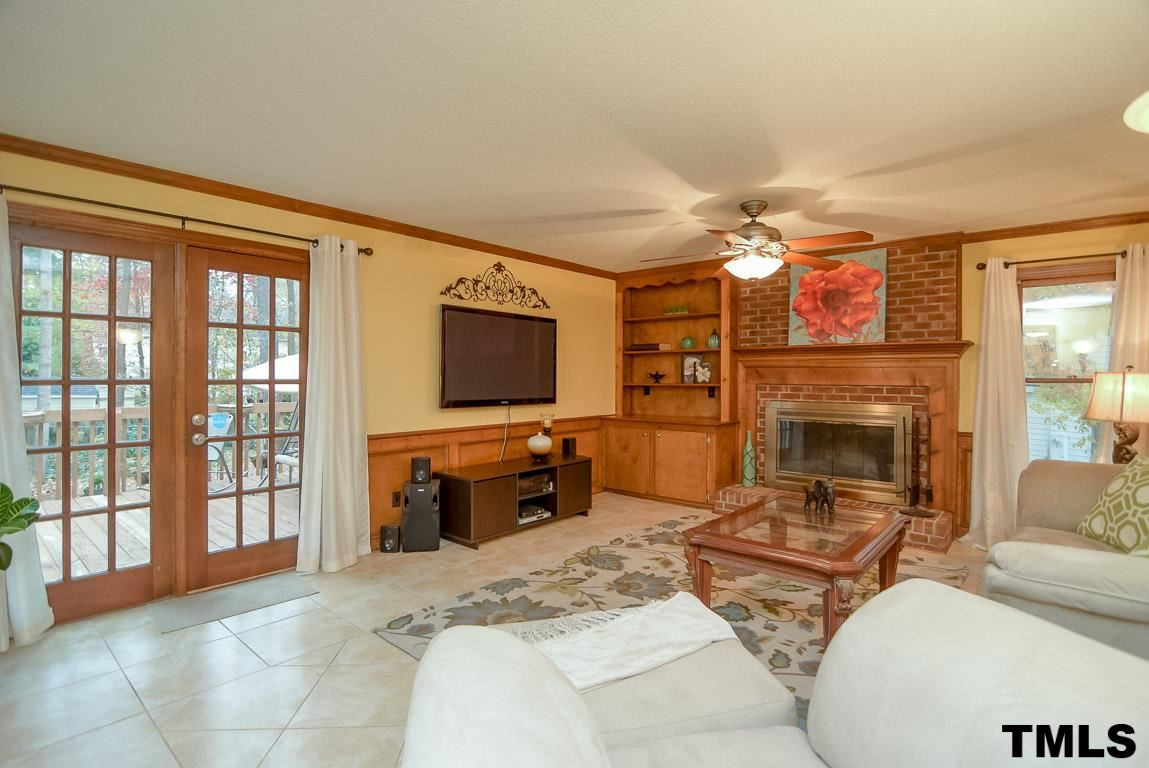 8101 Winstone Court Raleigh, NC 27615 - Photo 7 of 25 Family room with tile floor, brick fireplace, and crown molding. Den/Family/Great Room