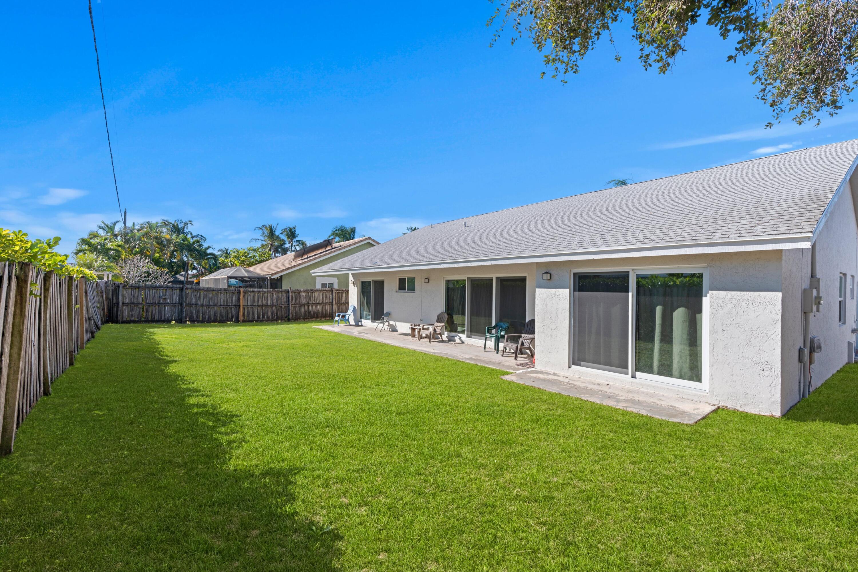 7944 Texas Trail Boca Raton, FL 33487 - Photo 16 of 27 a front view of a house with a garden and yard