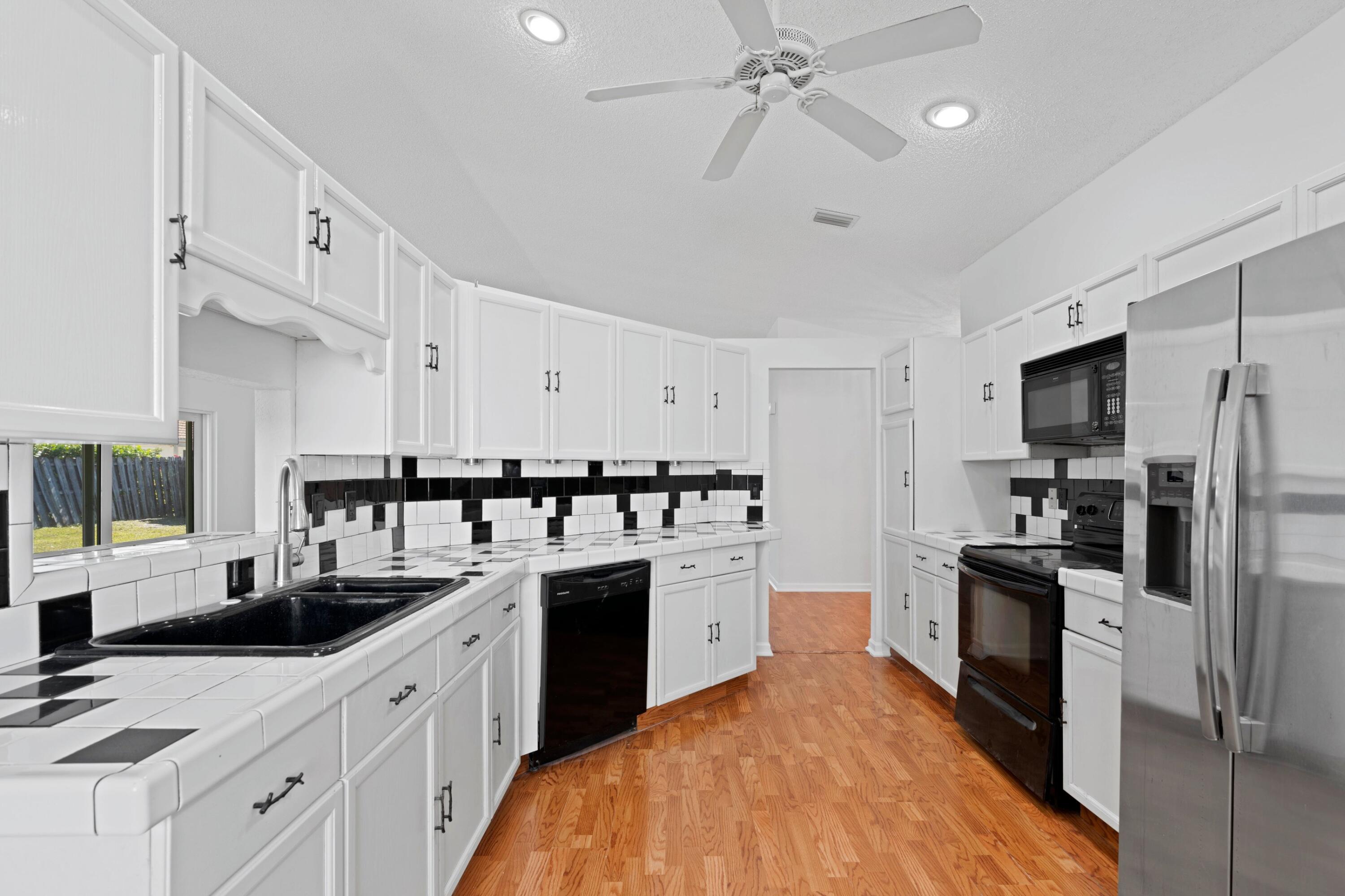 7944 Texas Trail Boca Raton, FL 33487 - Photo 8 of 27 a kitchen with stainless steel appliances a sink cabinets and refrigerator